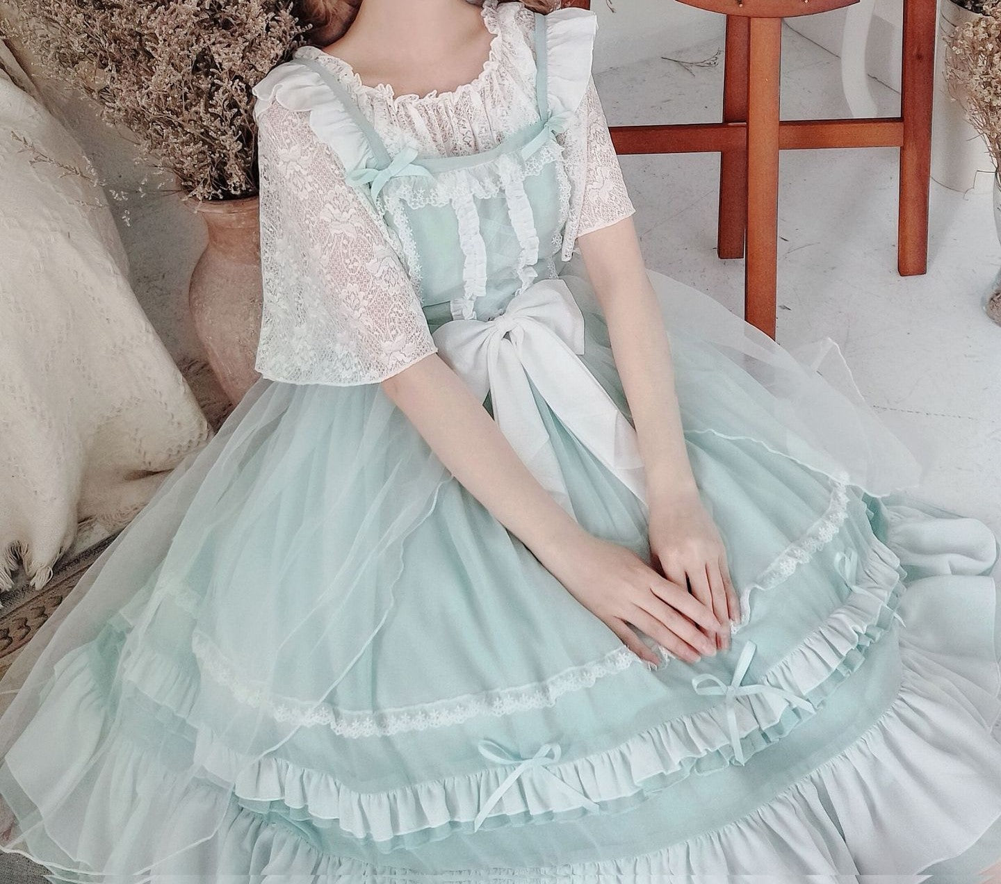 Person wearing a light blue and white dress sitting on a couch.