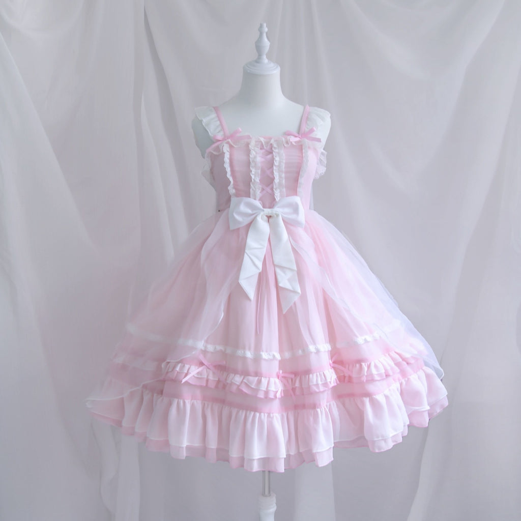 Pink lace dress with a white bow on a mannequin against a plain background